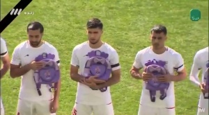 伊朗队赛前全员手捧书包，悼念此前在空袭中丧生的上百名儿童